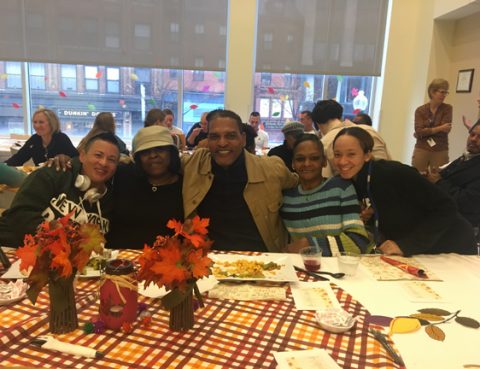 Five people pose at a table.