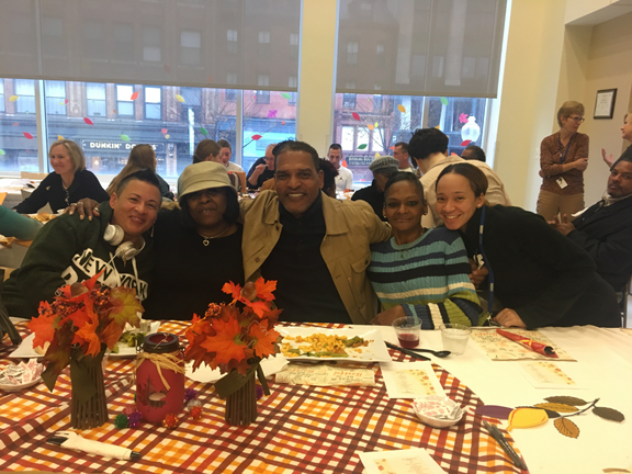 Five people pose at a table.