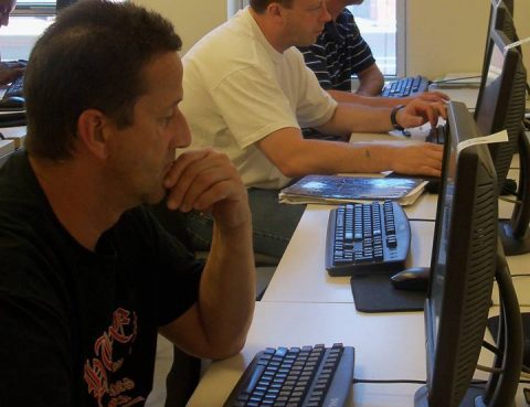 Three men using computers.
