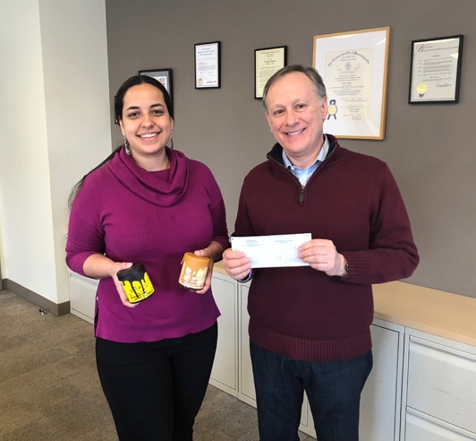 A man and a woman pose with a check