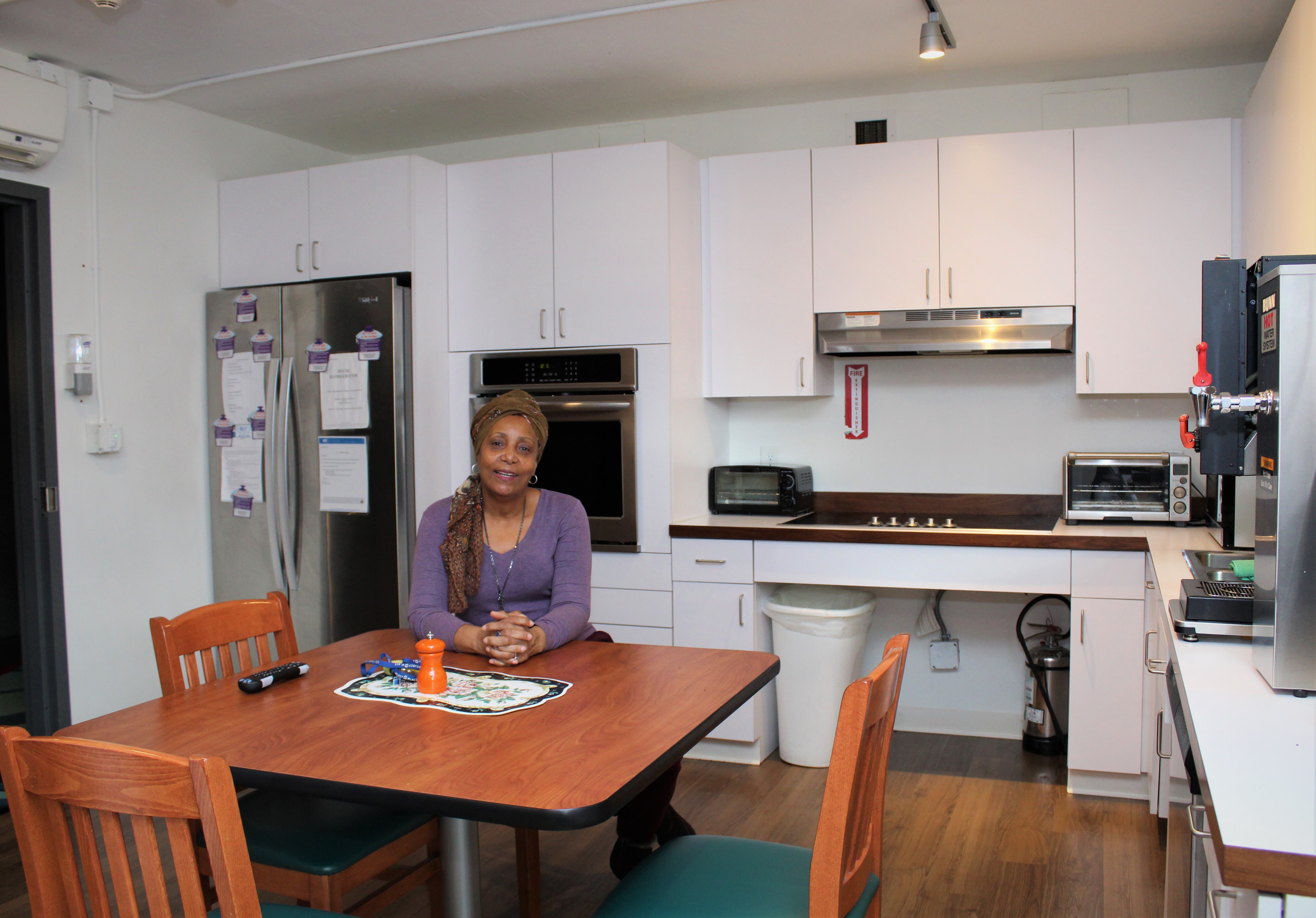 Yolette sitting at the kitchen table in Betty's Place
