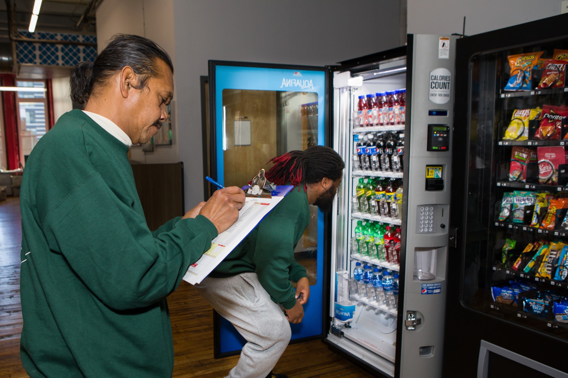 two clients in our LEAP social enterprise taking inventory and stocking a vending machine