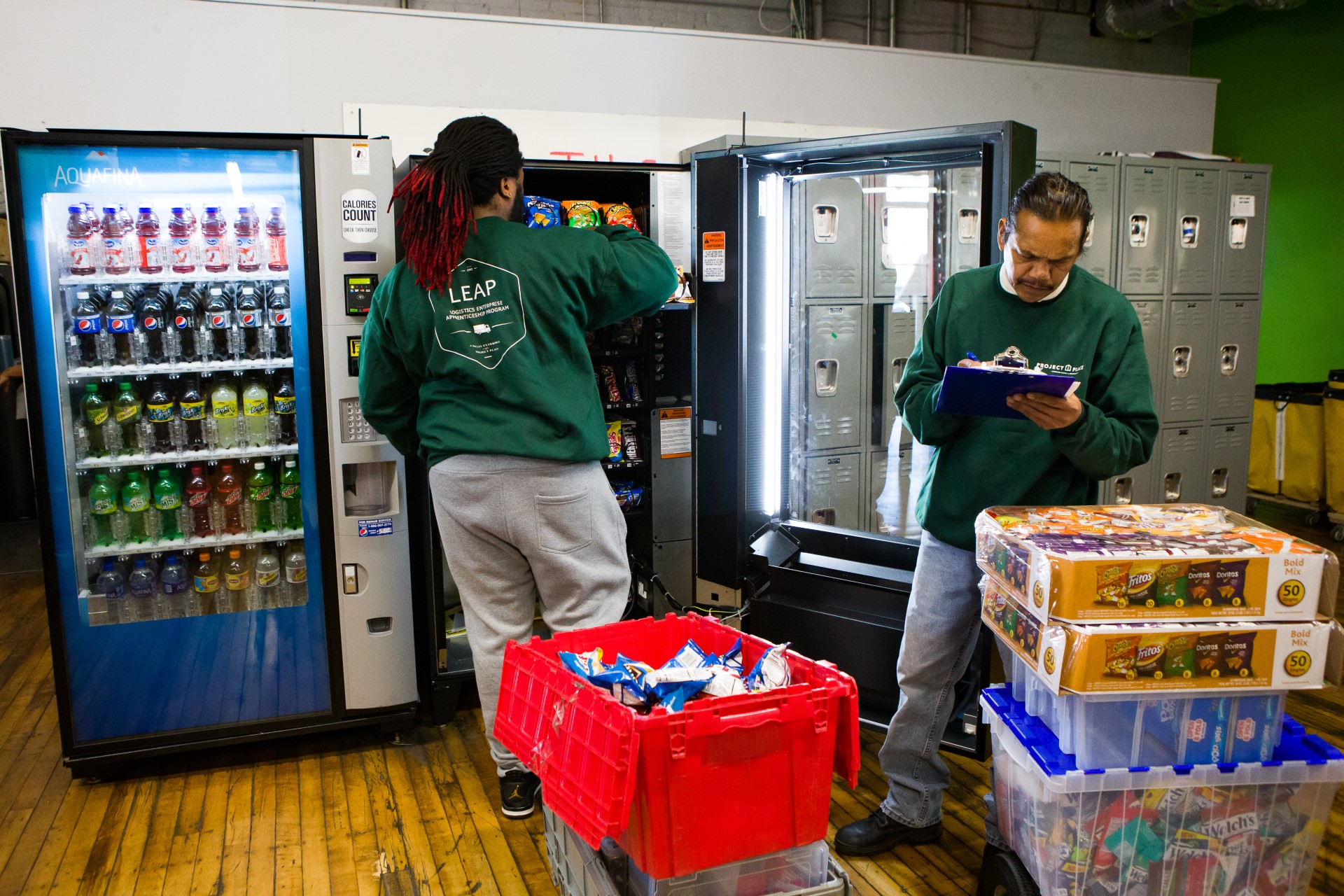 two clients in our LEAP social enterprise taking inventory and stocking a vending machine