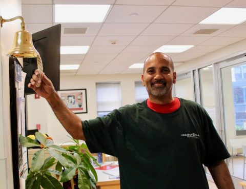 a newly employed client ringing the job bell on the wall